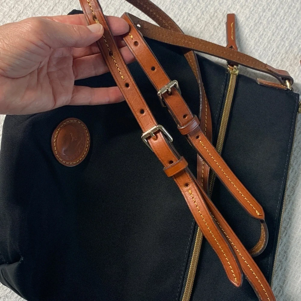 Dooney & Bourke black nylon crossbody bag with brown leather strap and accents